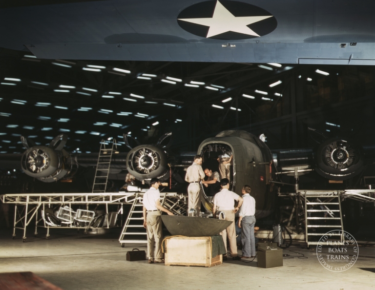 Getting a nose door ready to put on a C-87 transport plane at the end of the assembly line at the Consolidated Aircraft Corporation plant, Fort Worth, Texas